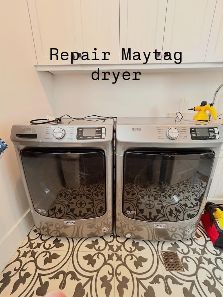 Two Maytag dryers side by side in a laundry room with a Repair Maytag dryer sign above them