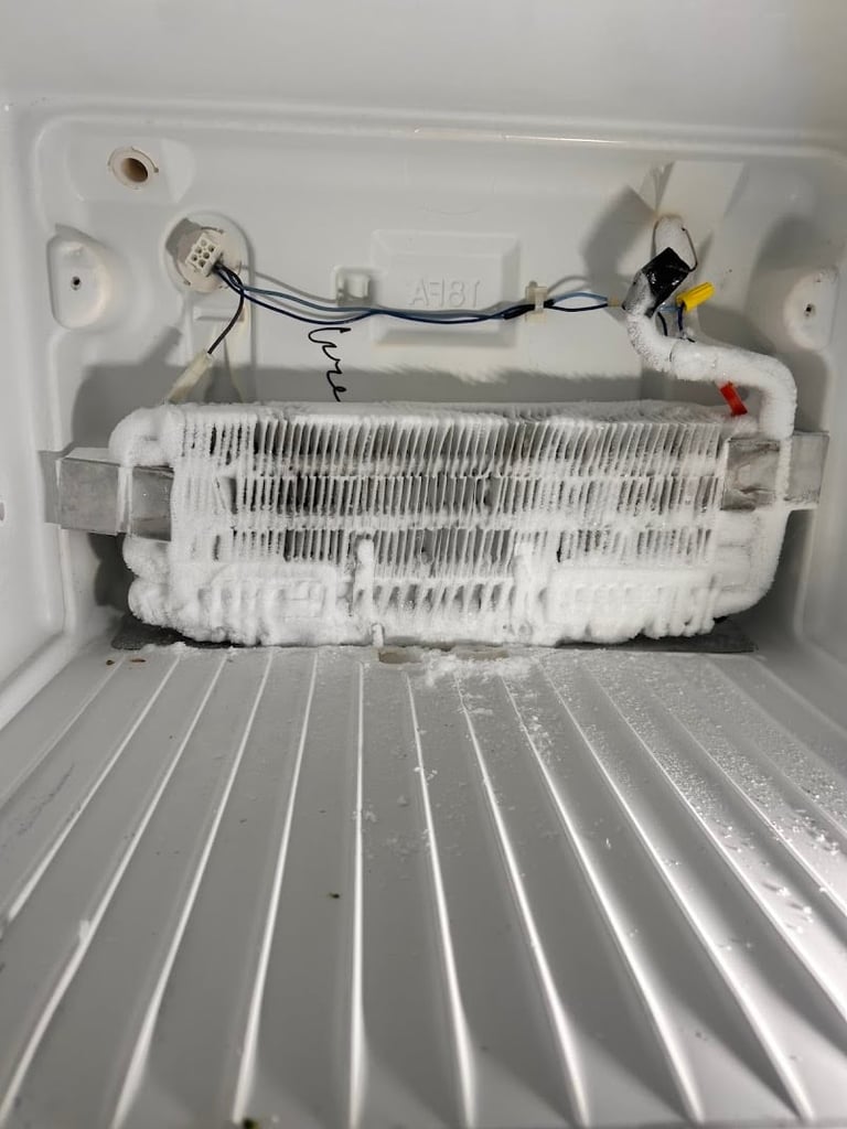 Interior of a refrigerator showing the heating element and evaporator coil with visible frost and icing buildup on the cooling fins.